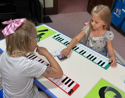 2 girls working on an activity at a table