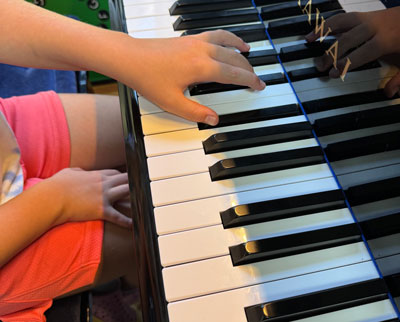 child's hand on piano keys